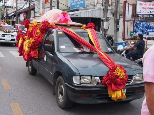 The turtle being carried at the front of the parade on the rooftop and all decorated with real flowers